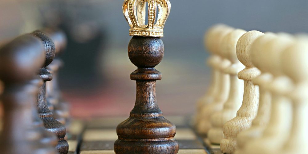 A brown pawn with a crown stands prominently on a chessboard, symbolizing strategic play.